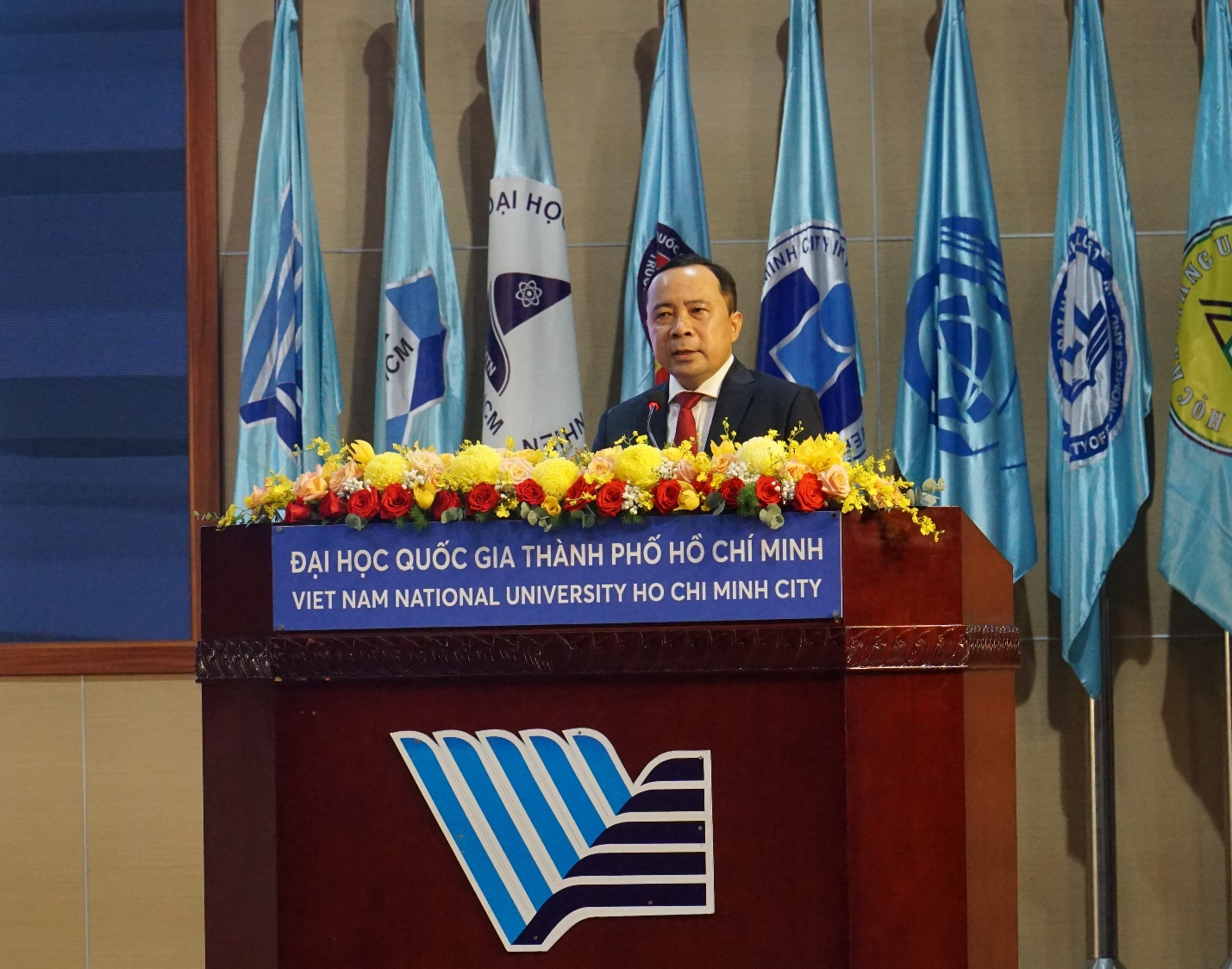 A person standing at a podium

Description automatically generated